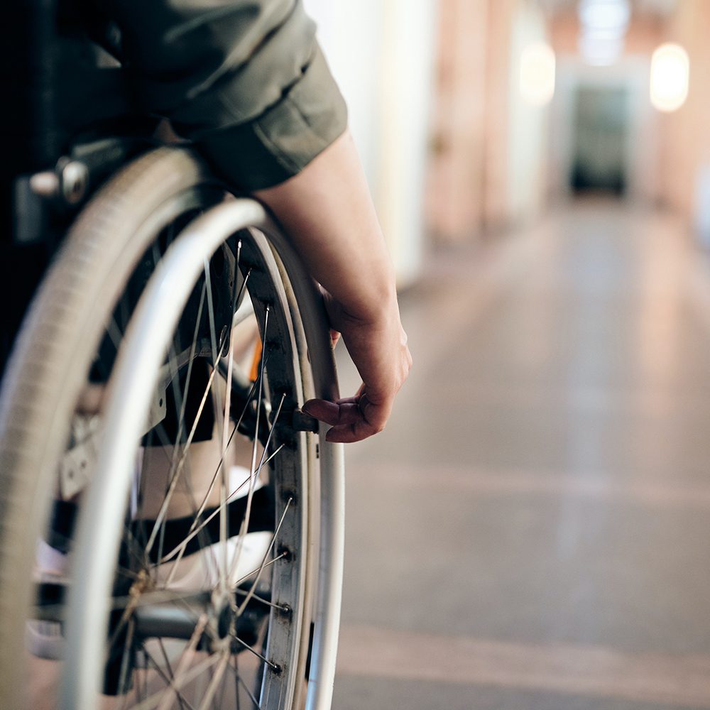 man touching wheelchair wheels